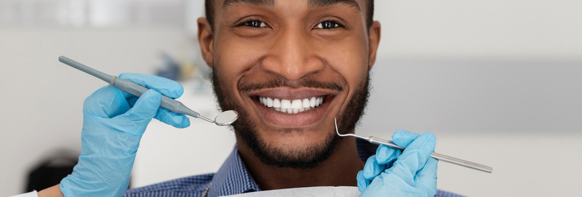 A young man smiling at the dentist during examination